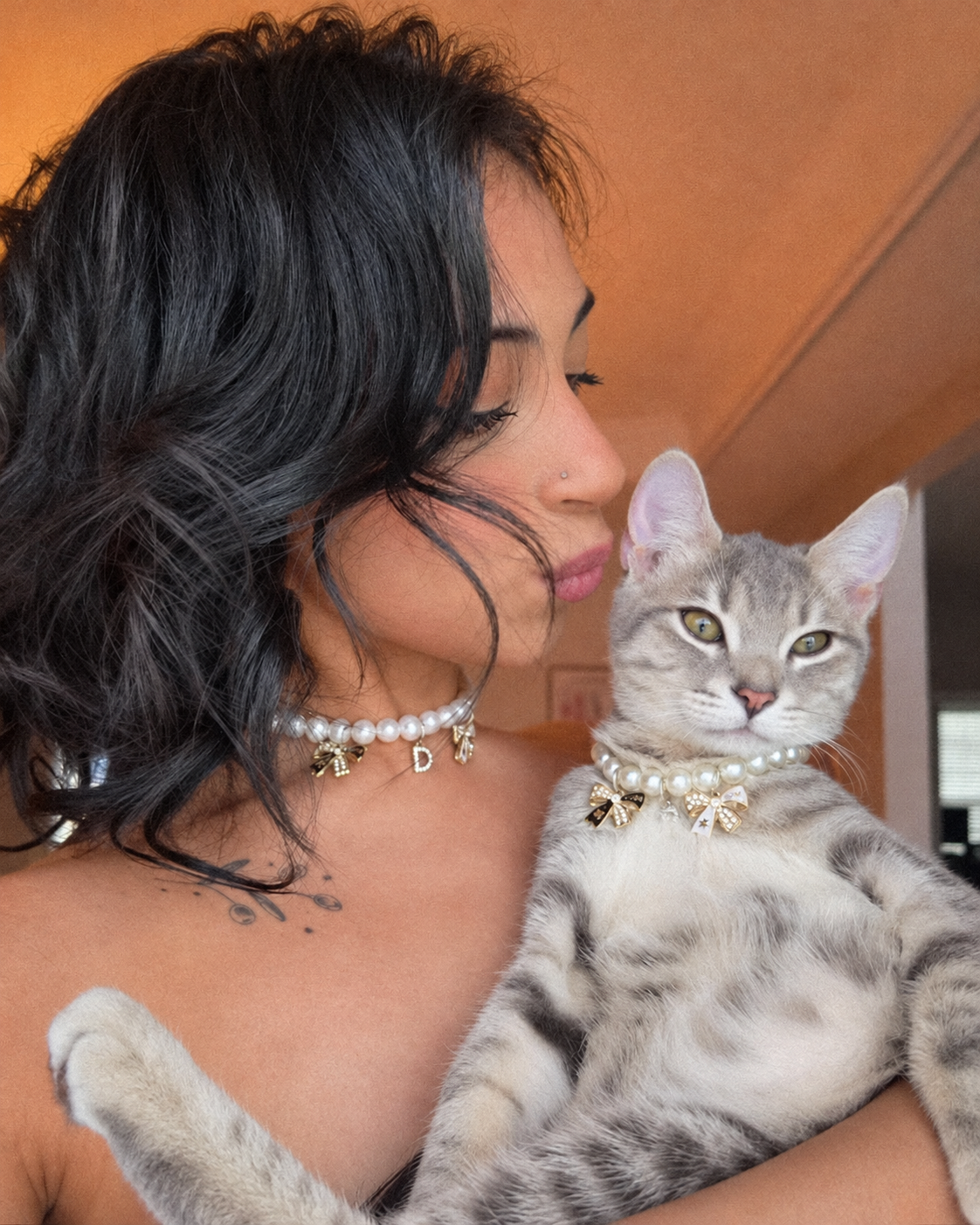 Woman and her tabby kitten wearing matching freshwater pearl necklaces