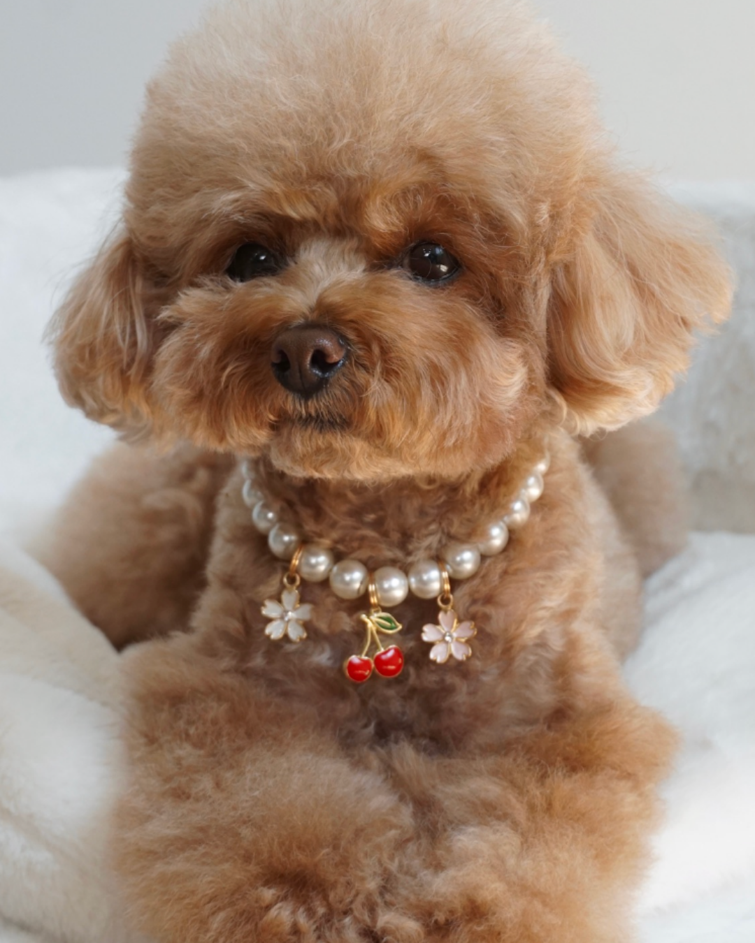 Faux pearl necklace with cherry and flower charms